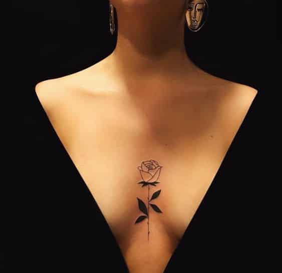 Tatuagem feminina de rosa entre meio as mamas site tattooandyou.com