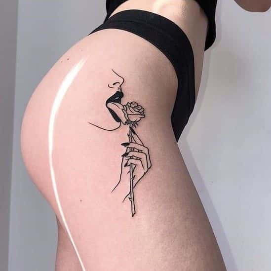 Tatuagem feminina de mulher lambendo rosa na coxa site tattooandyou.com