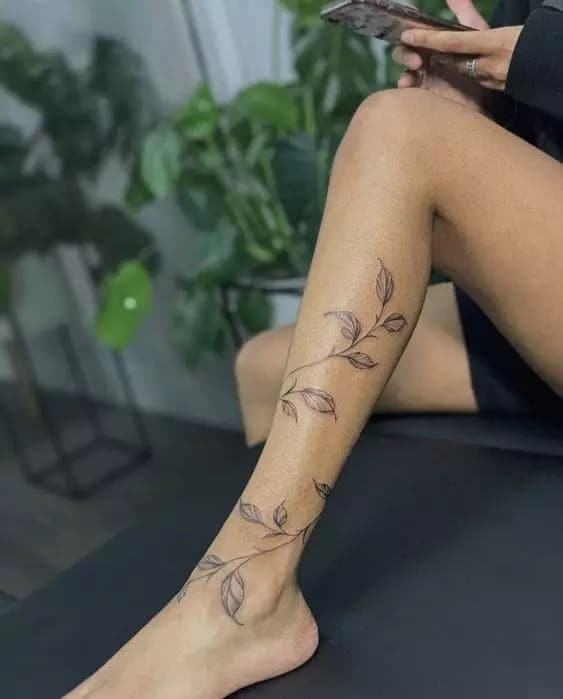 as tatuagens na canela mais bonitas atualmente ramo de folhas